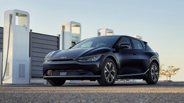 A dark car in front of a gate.