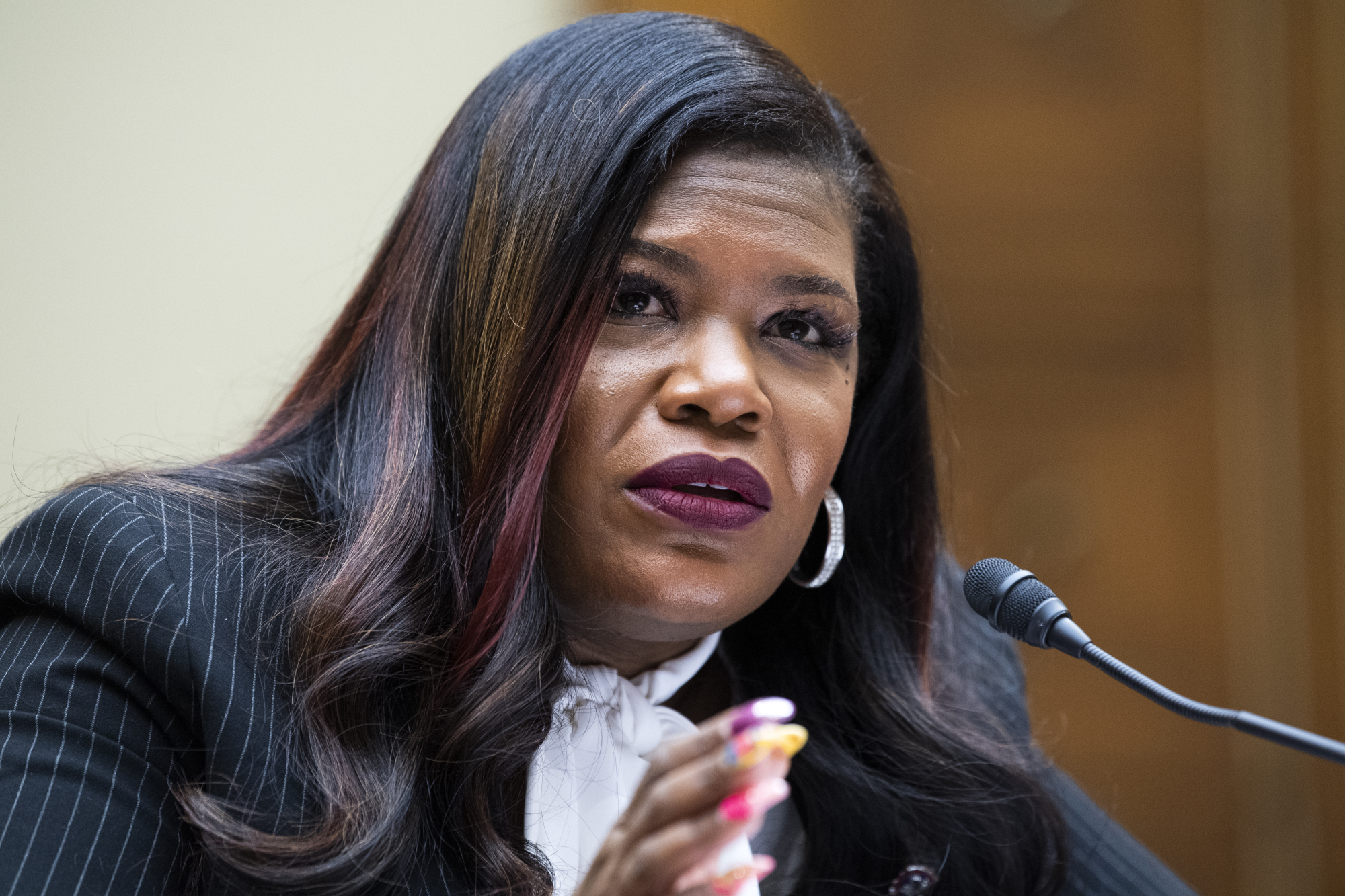 Representative Cori Bush speaks into a microphone during a congressional hearing.