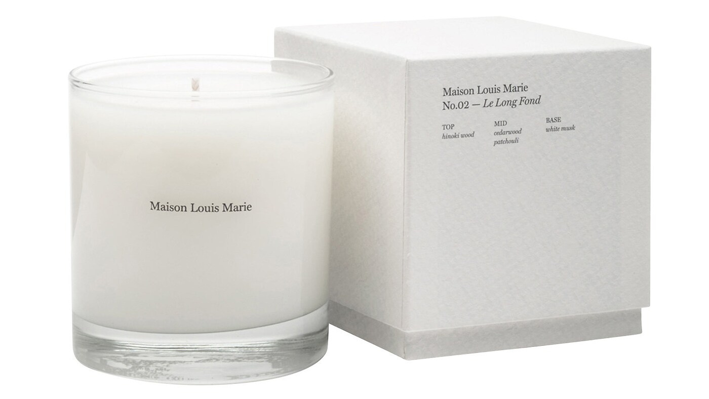 White scented candle next to its product box