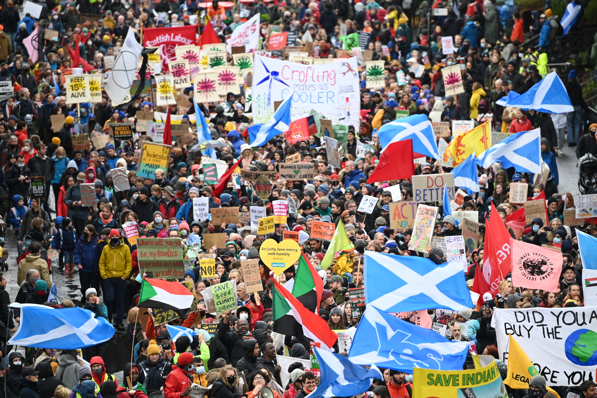 An overhead shot of a large crowd marching through the streets of Glasgow.