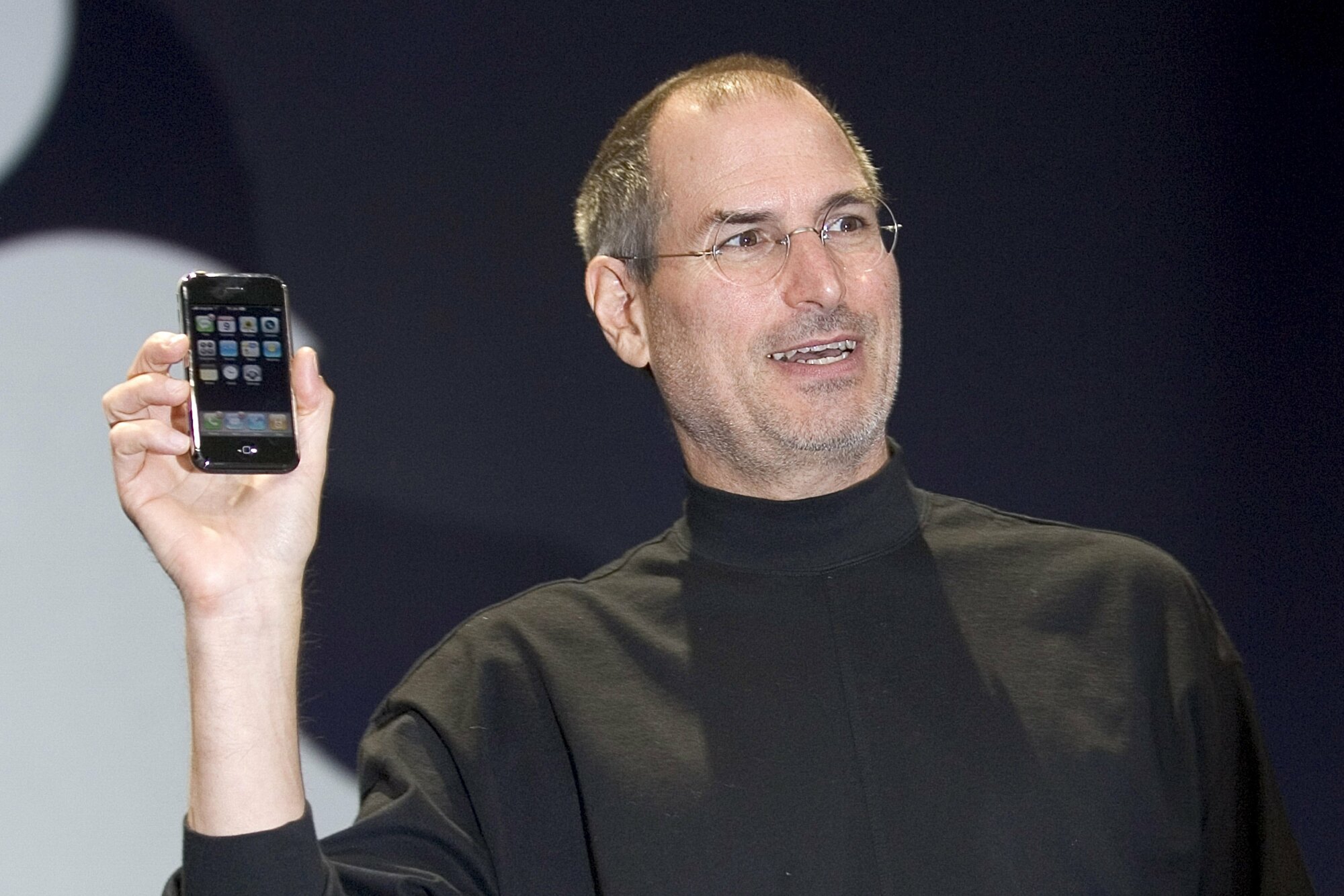 Image of Steve Jobs holding up the first iPhone