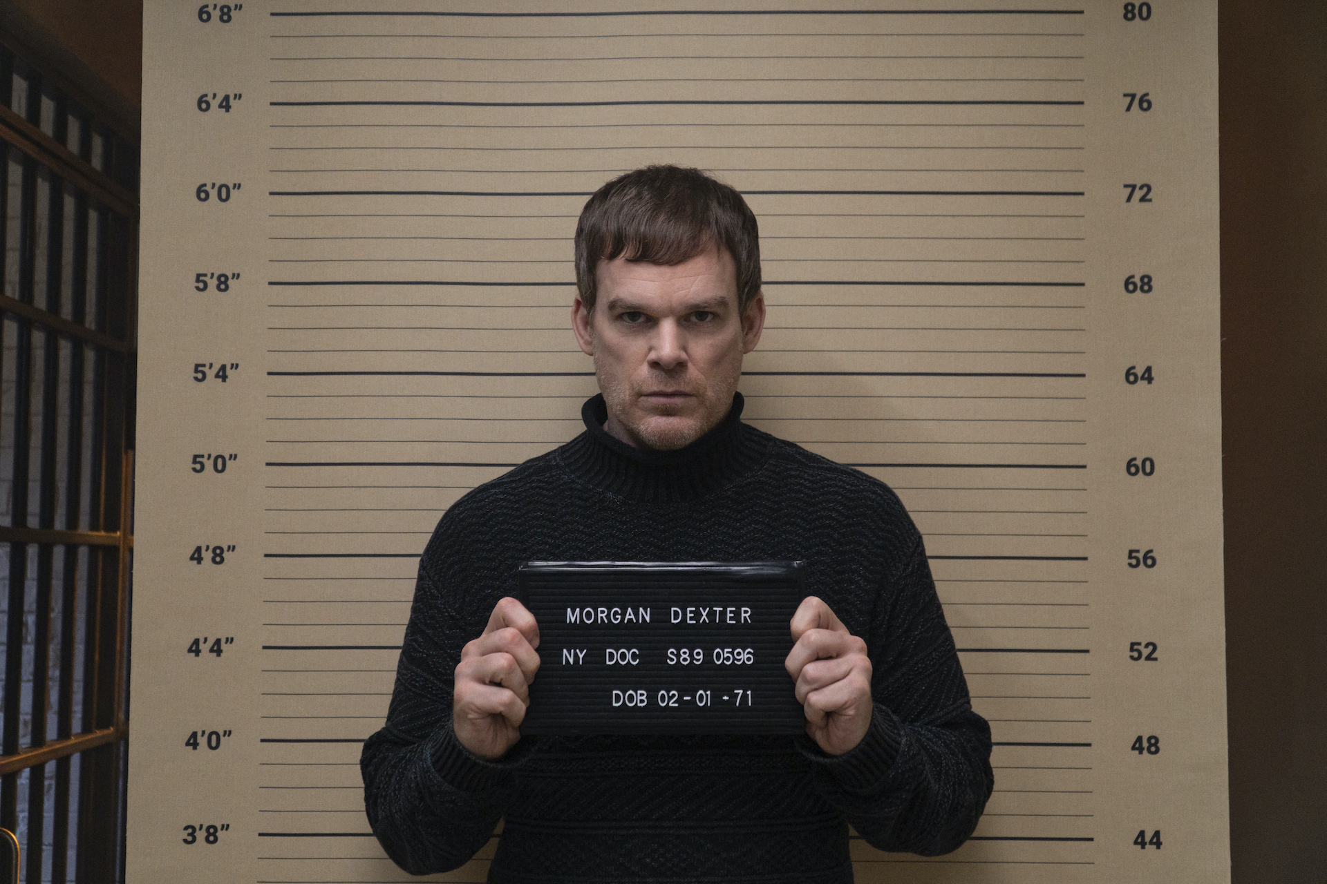 A middle-aged white man getting a mug shot photo snapped.