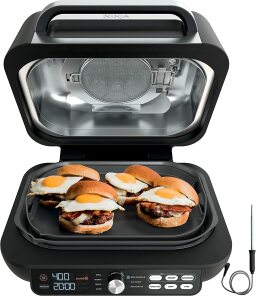Ninja indoor grill with breakfast sandwiches cooking on it