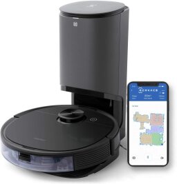 Black robot vacuum at self-empty station with phone screen displaying map of home
