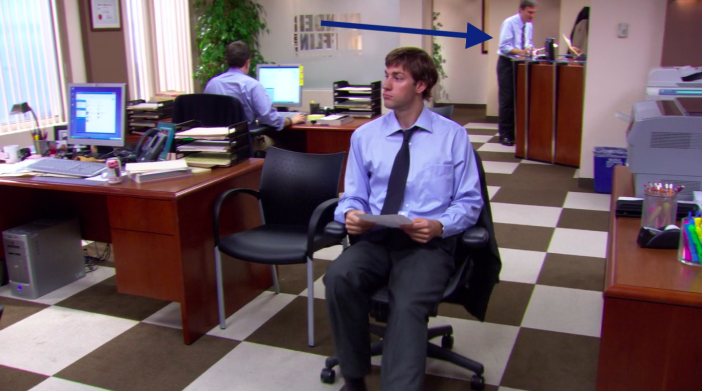 A scene from "The Office" that shows a man and a woman speaking at the reception desk.