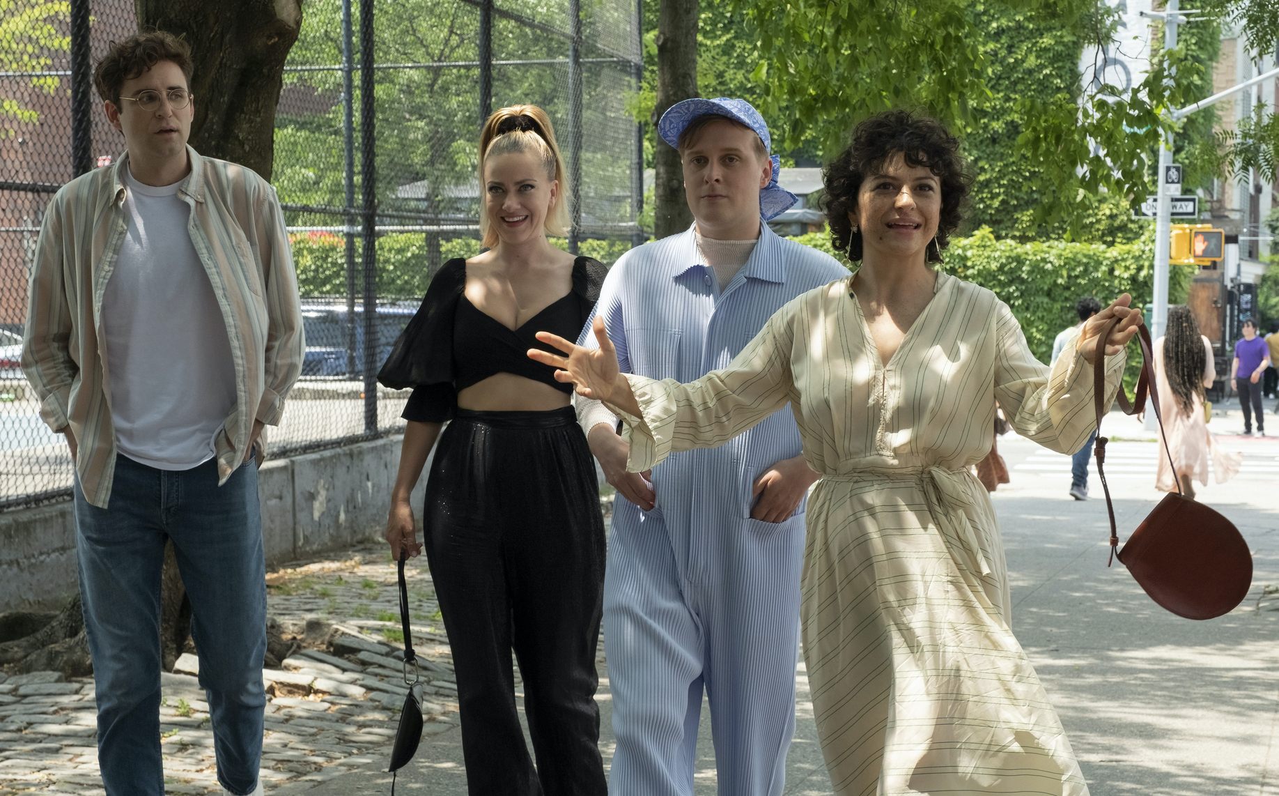 Two men and two women walk through a park on a sunny day in New York City.