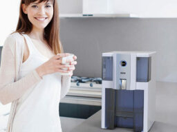 Person next to the RKIN AlcaPure Countertop Water Purifier with Filters.