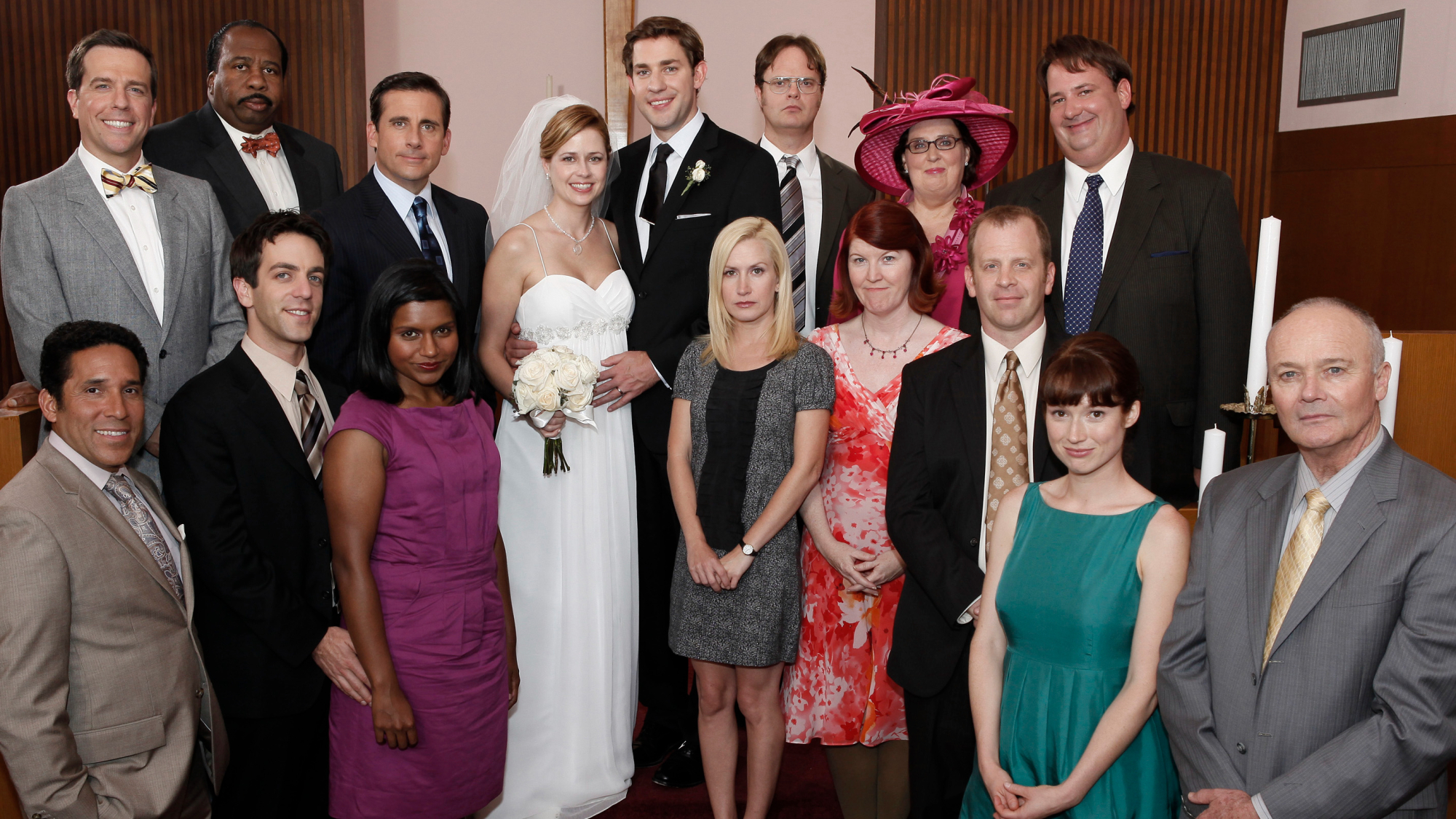 A large group of people poses for a wedding photo