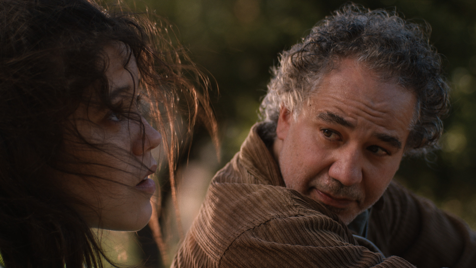 A teen girl sits with her father, who looks concerned.