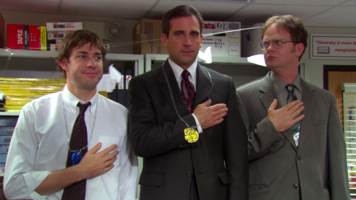 Three men (John Krasinski who plays Jim Halpert on "The Office," Steve Carell who plays Michael Scott, and Rainn Wilson who plays Dwight Schrute) standing on a makeshift Olympics podium in an office.