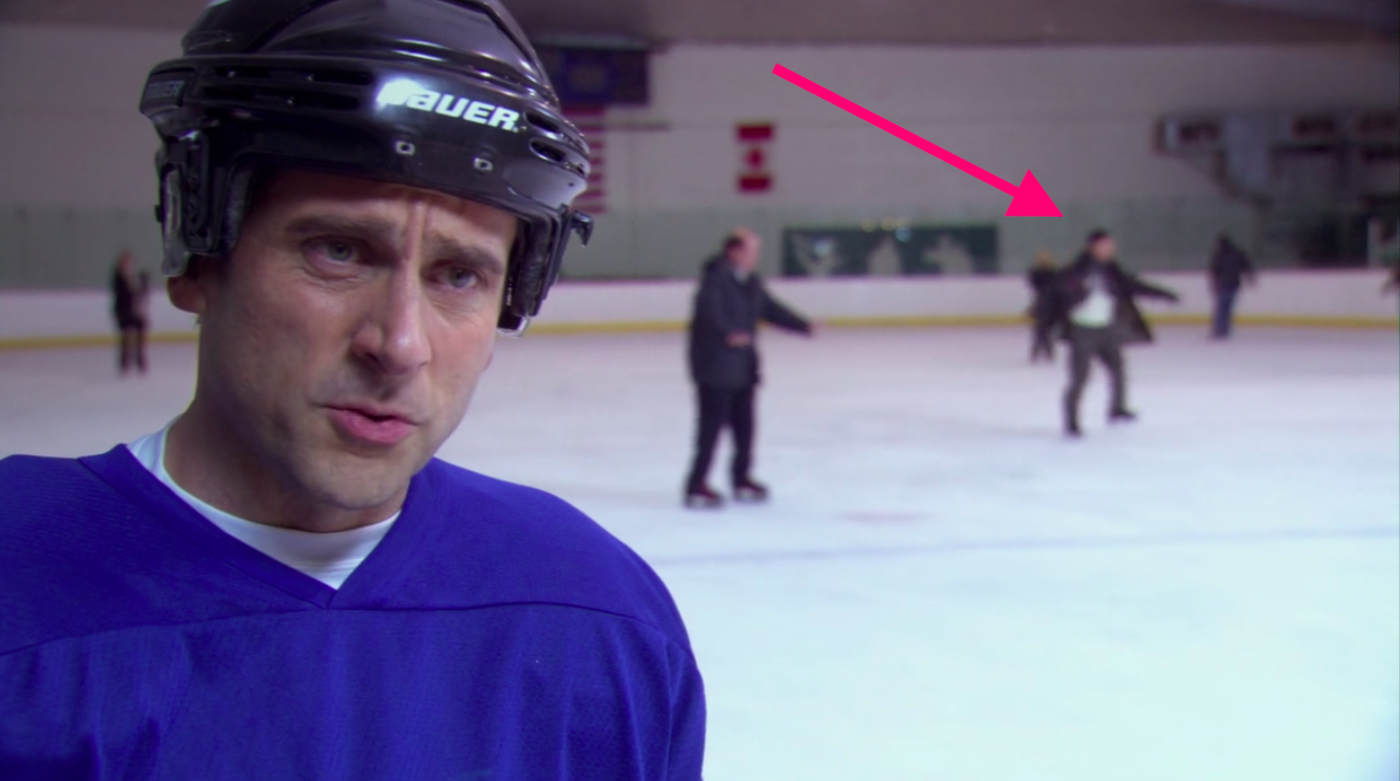 Several people on an ice skating rink with an arrow pointing to one professional skater.
