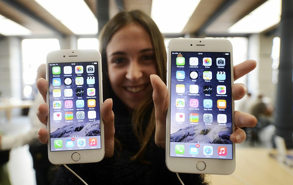 Image of woman holding up iPhone 6 and iPhone 6 Plus 