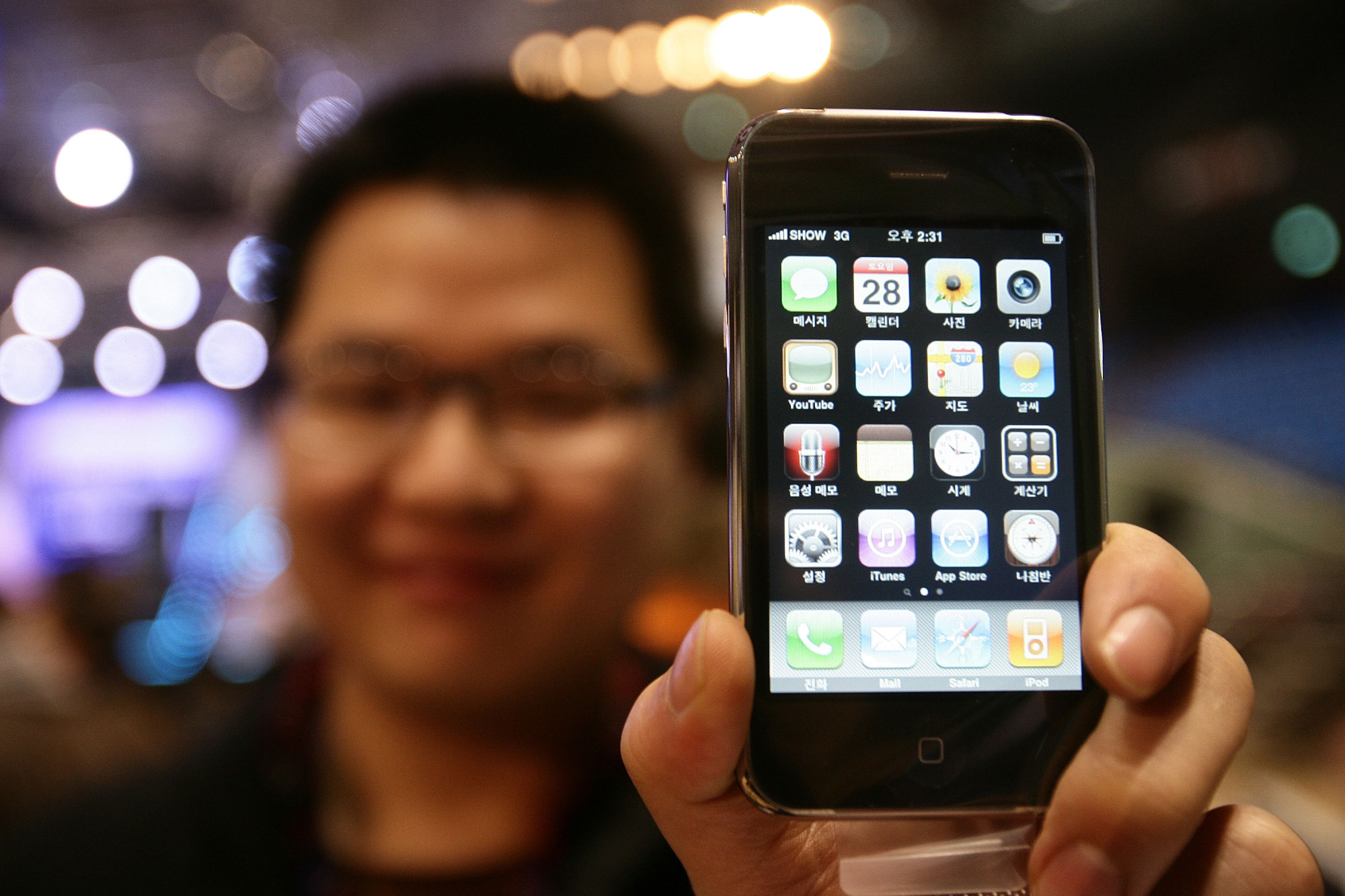 Image of man holding up the iPhone 3GS