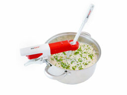Red and white automatic stirrer attached to chopsticks stirring creamy soup in metal pot