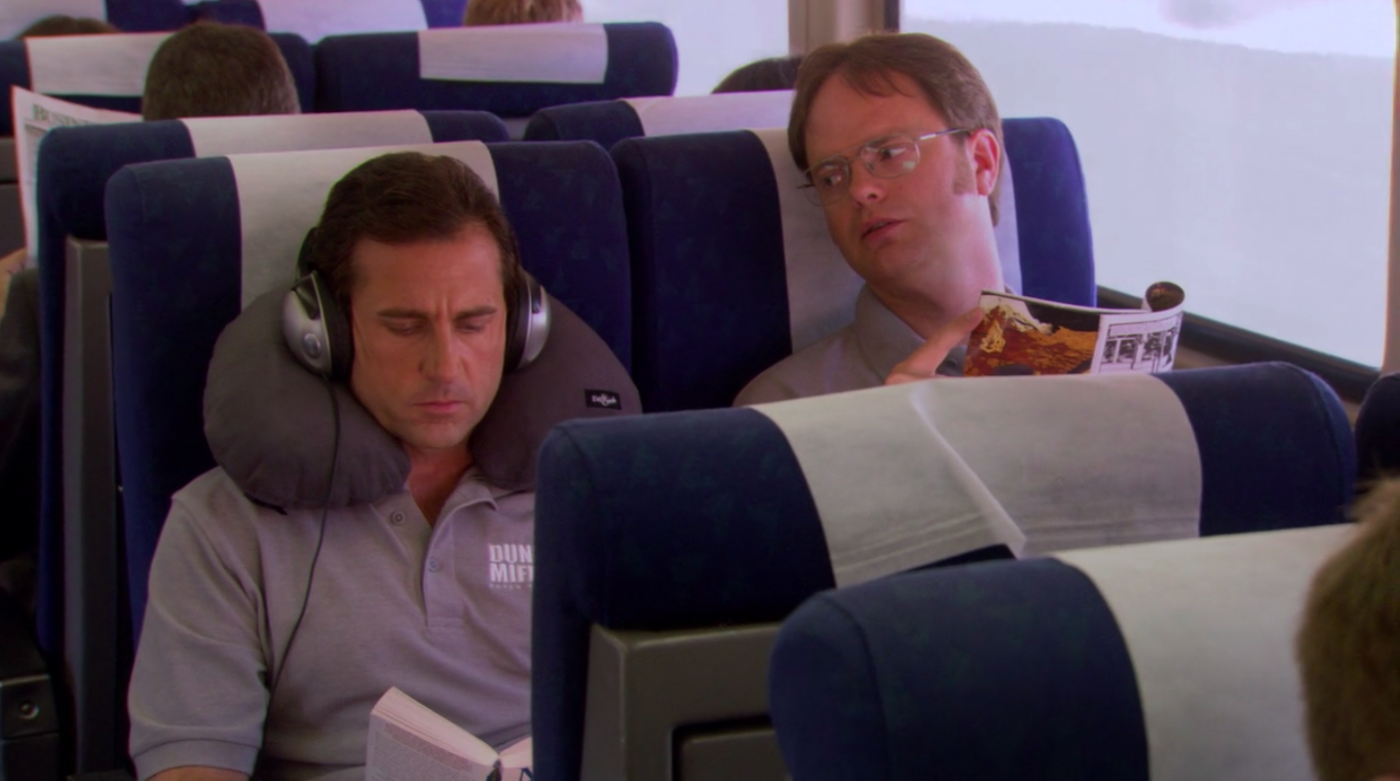 Two men, Steve Carell who plays Michael Scott on "The Office" and Rainn Wilson as Dwight Schrute, sitting on an Amtrack train.