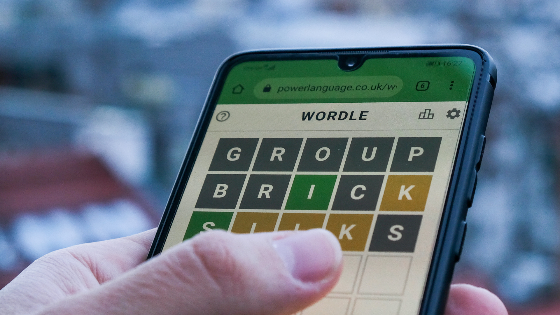 A smartphone showing a person playing Wordle.