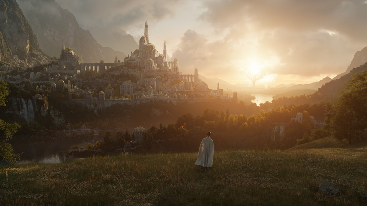 A white-cloaked figure stands on a hill overlooking a beautiful city. In the distance stand two massive trees: one light and one dark.