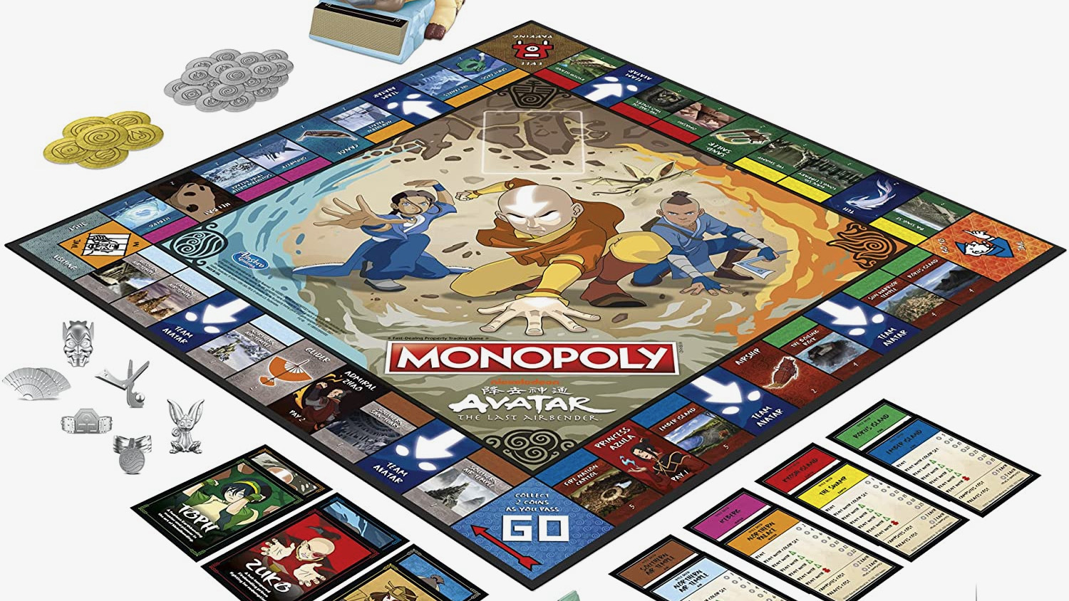 Board game of Avatar Monopoly with cards, pieces, buildings, and dice