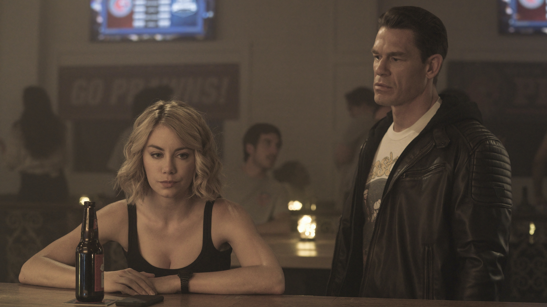 A man approaches a woman in a bar who looks like she wants to be left alone - a still from