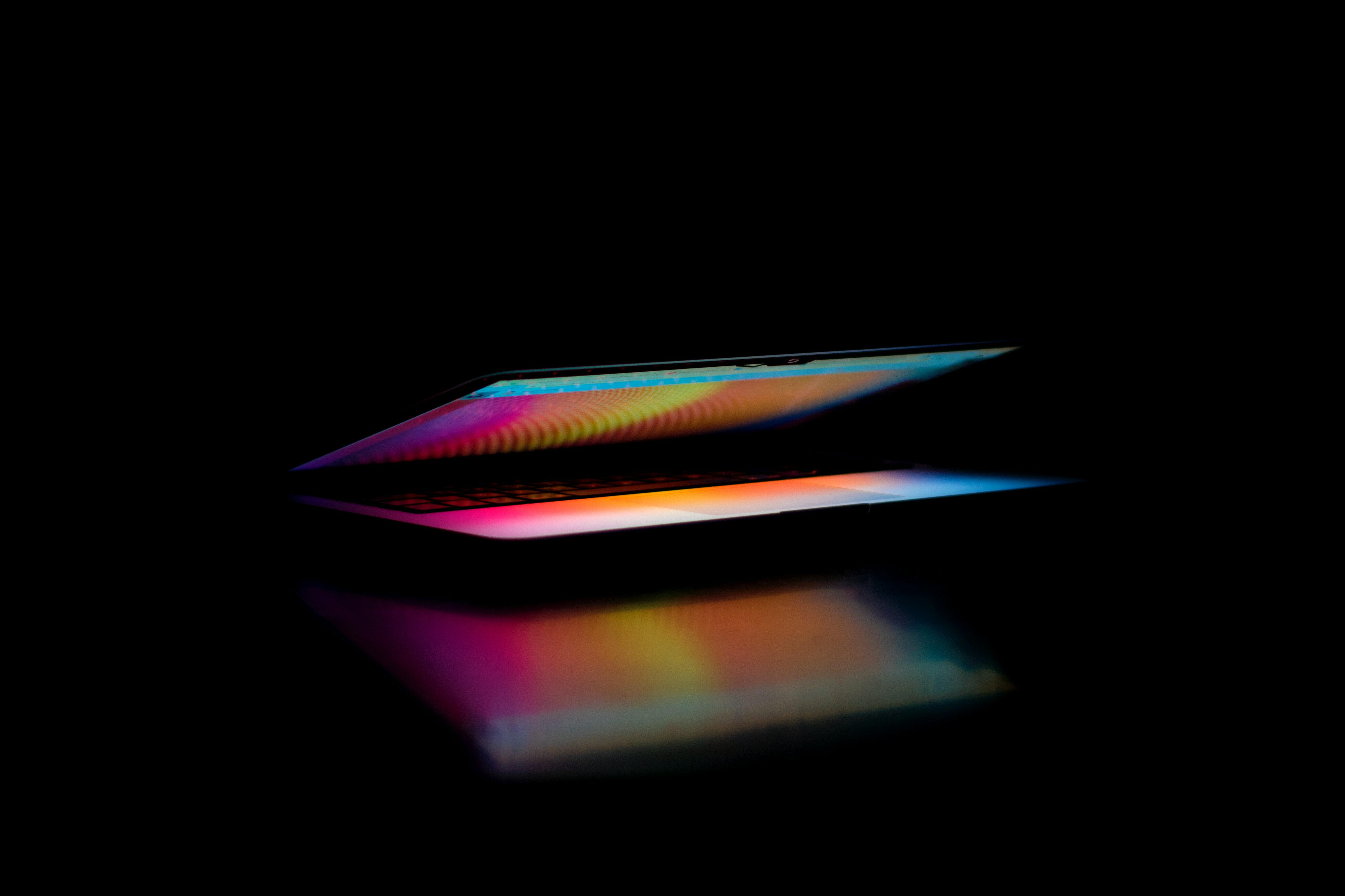 Laptop lit up in dark room