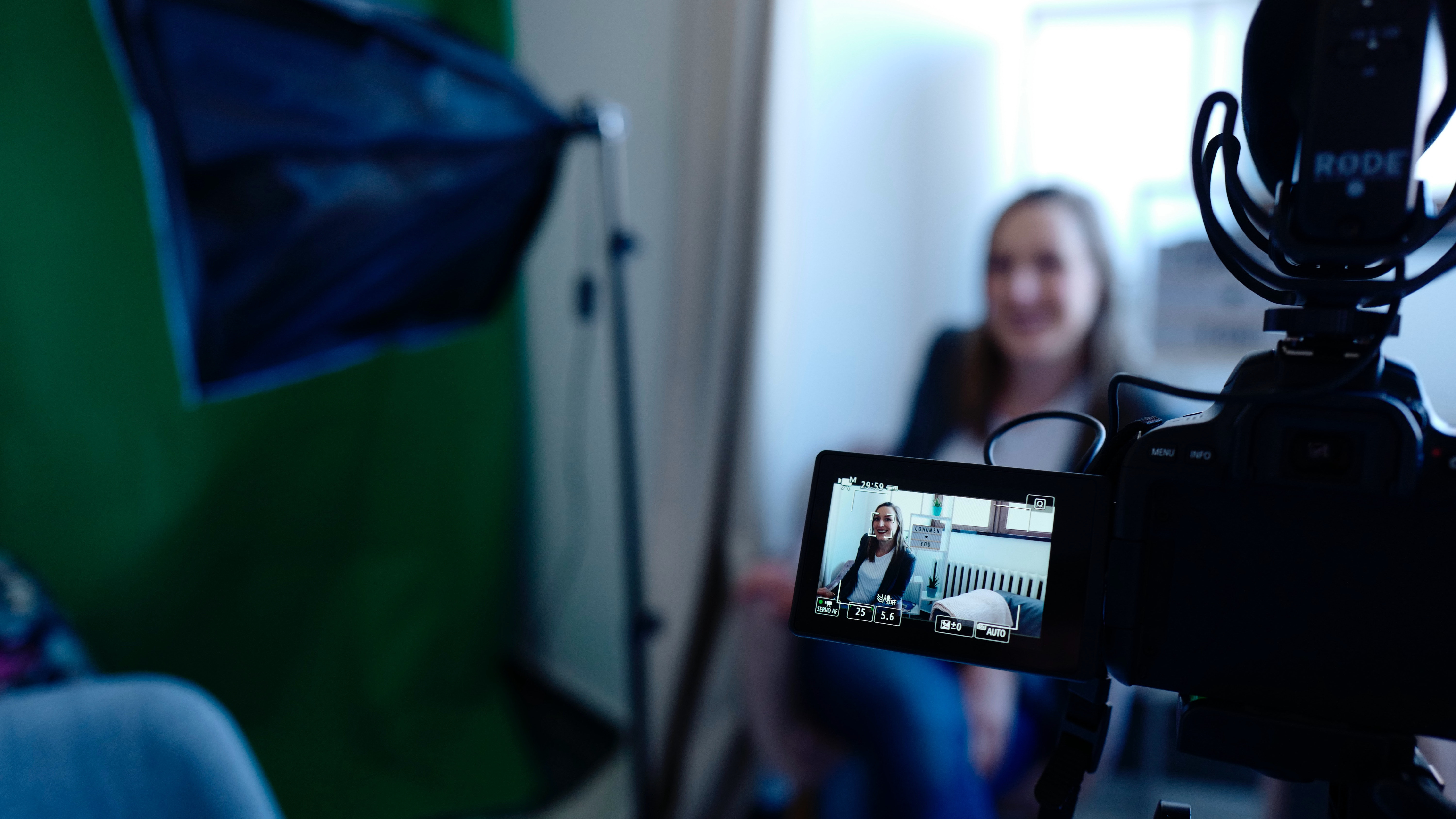 Video camera screen in focus with image of person speaking in front of the camera