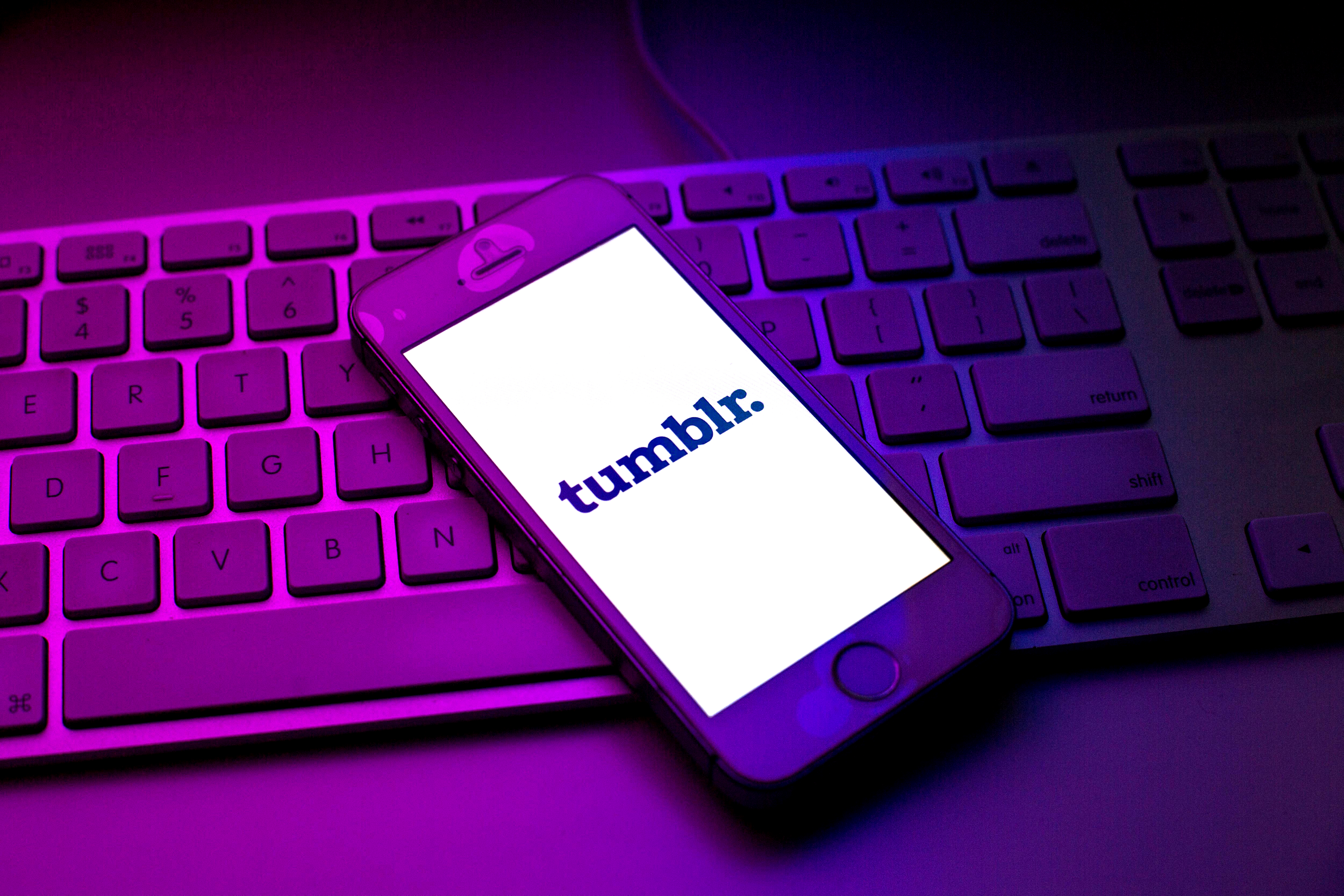 The Tumblr logo on a phone, resting on top of a keyboard