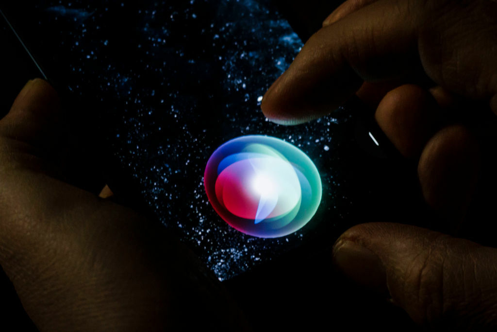 The Siri button illuminated on the iPhone screen.
