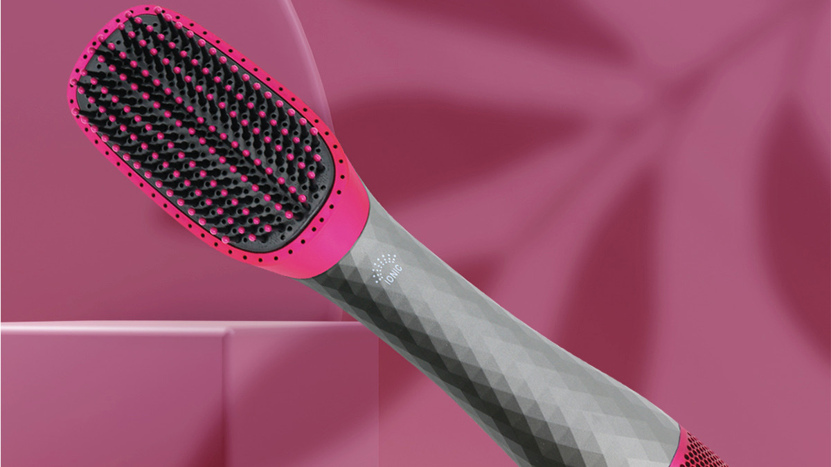 Pink and grey hairbrush over pink background