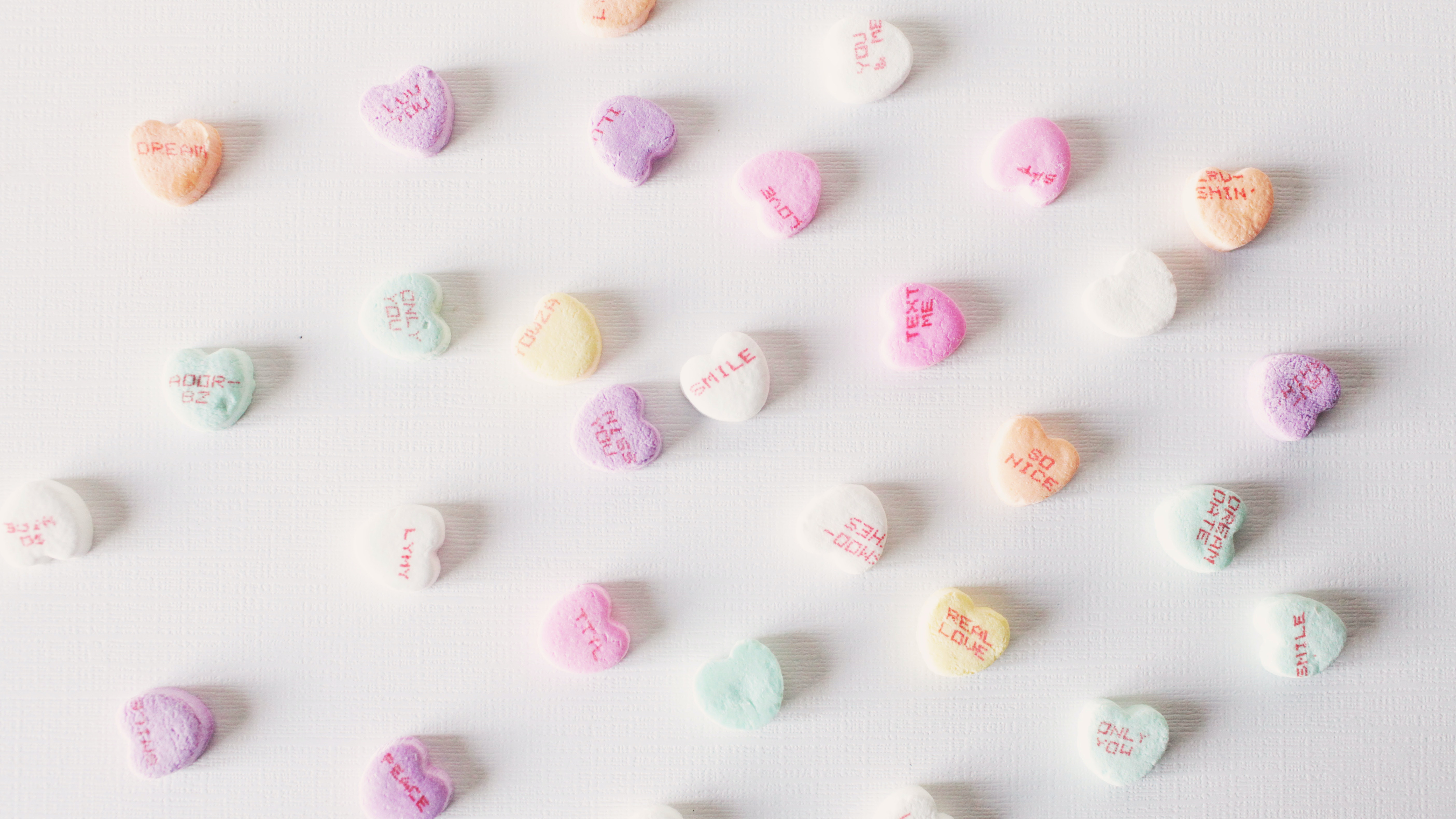 Scattered candy hearts with text