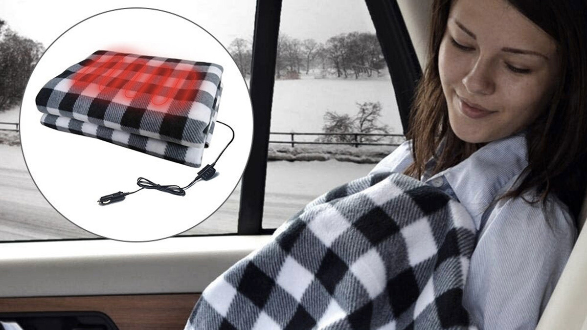 Person sleeping in car under black and white plaid blanket