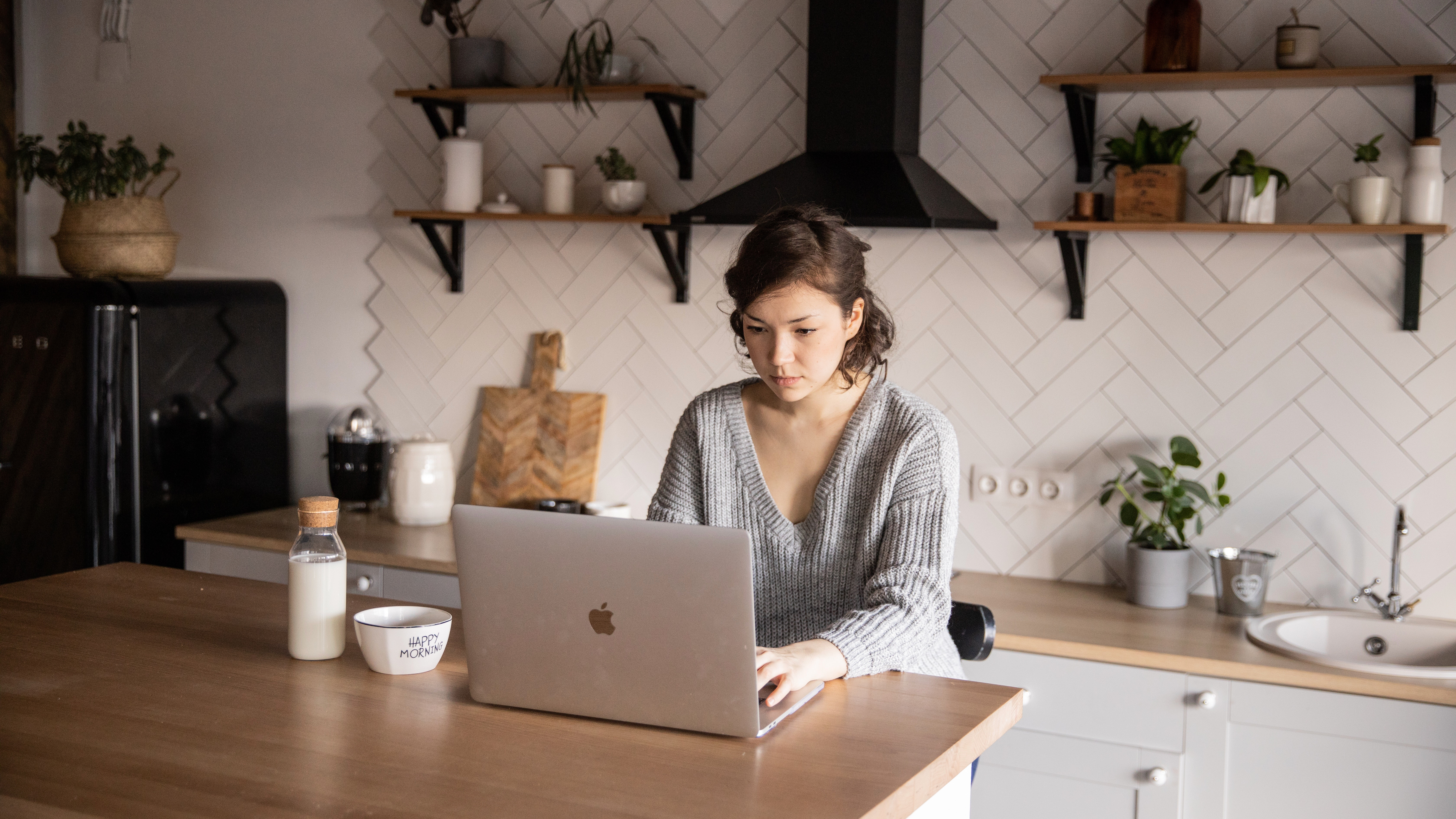Person sitting at kitchen table with laptop
