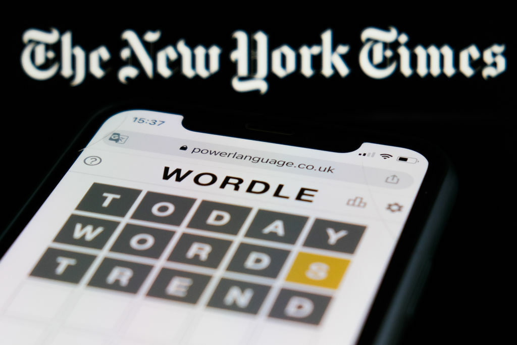 Wordle on a phone in front of the logo for the New York Times