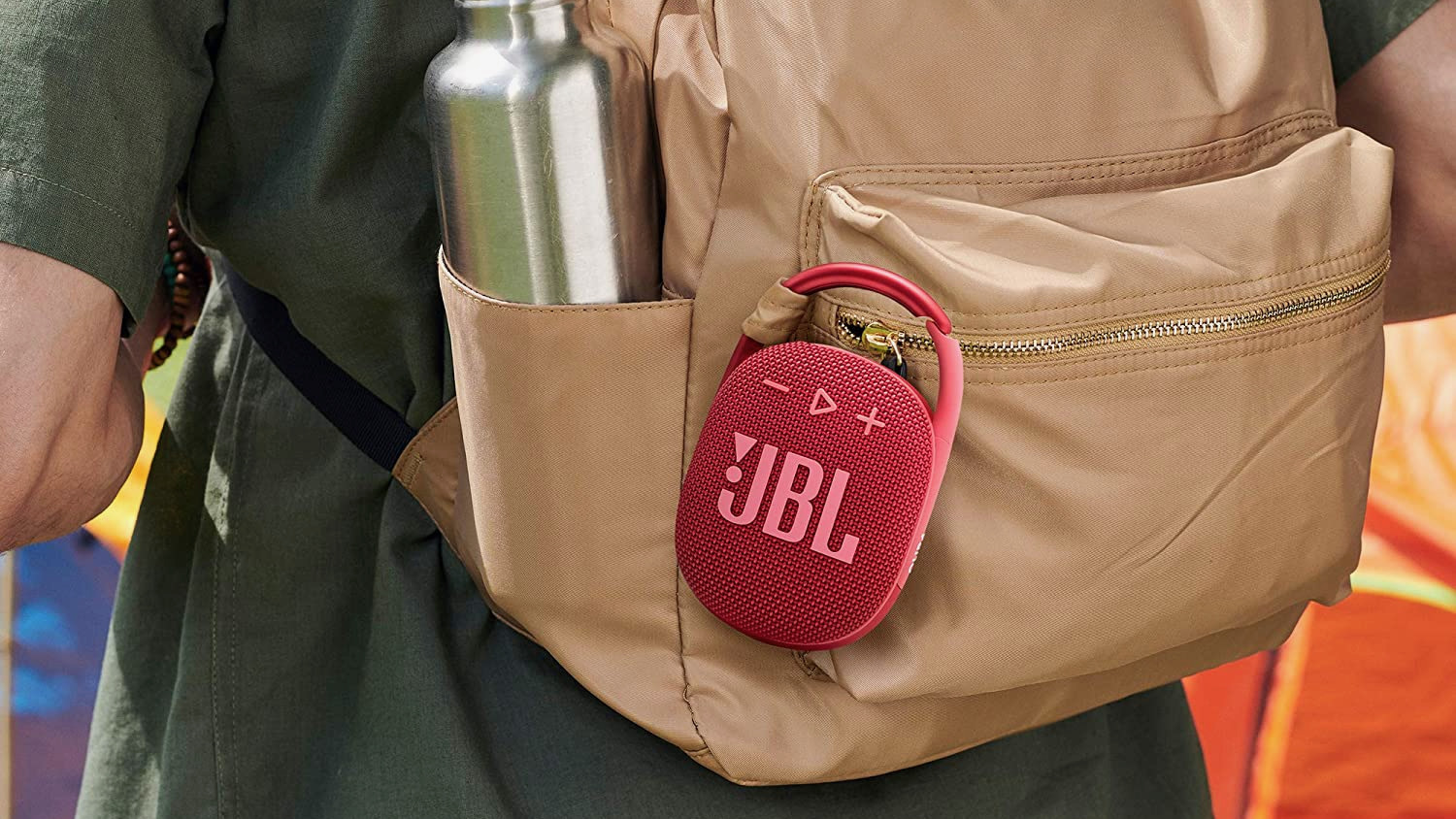 Red speaker clipped to tan backpack