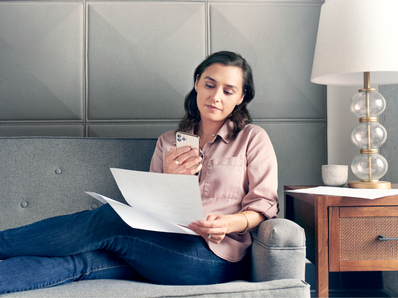 Woman doing taxes on her phone from the couch