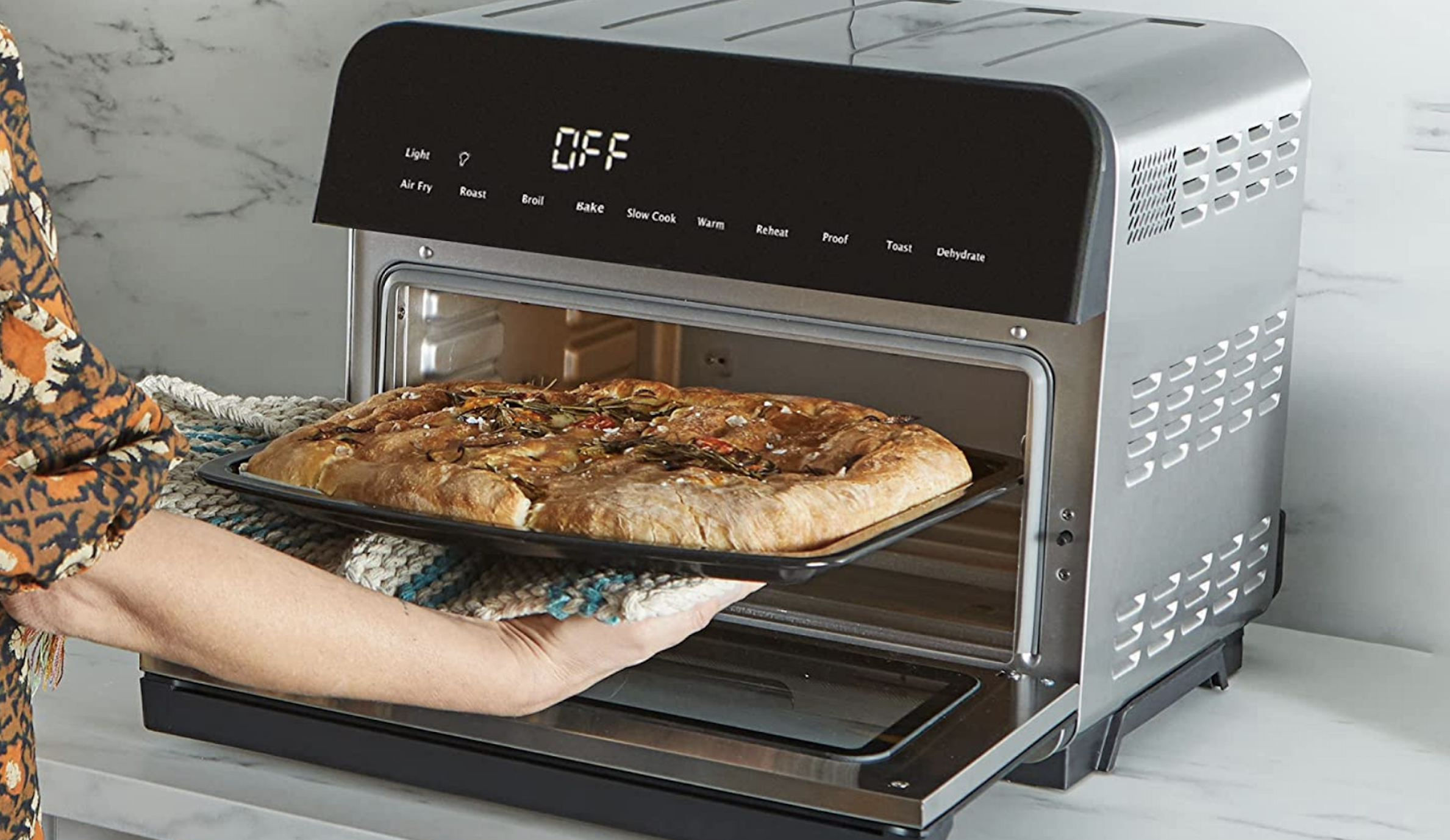 Person taking pizza out of Instant Omni Pro oven