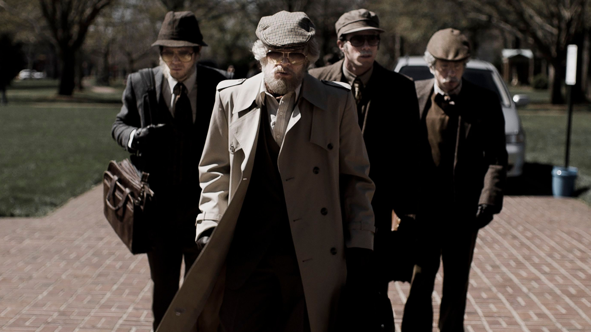 Four young men in disguises as old men.