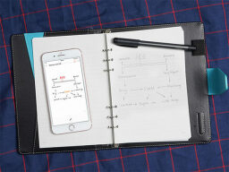 Notebook with phone and pen on it, text on both paper and screen matching.