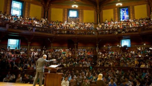 Image of professor at a lectern in a lecture hall