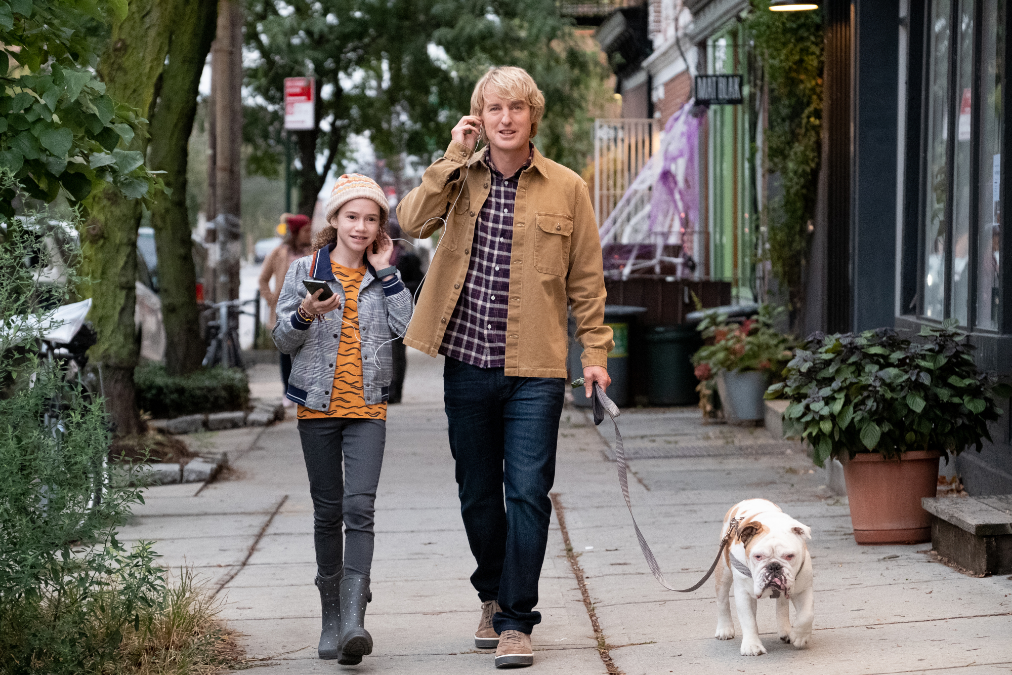 A father and daughter walk their bulldog.