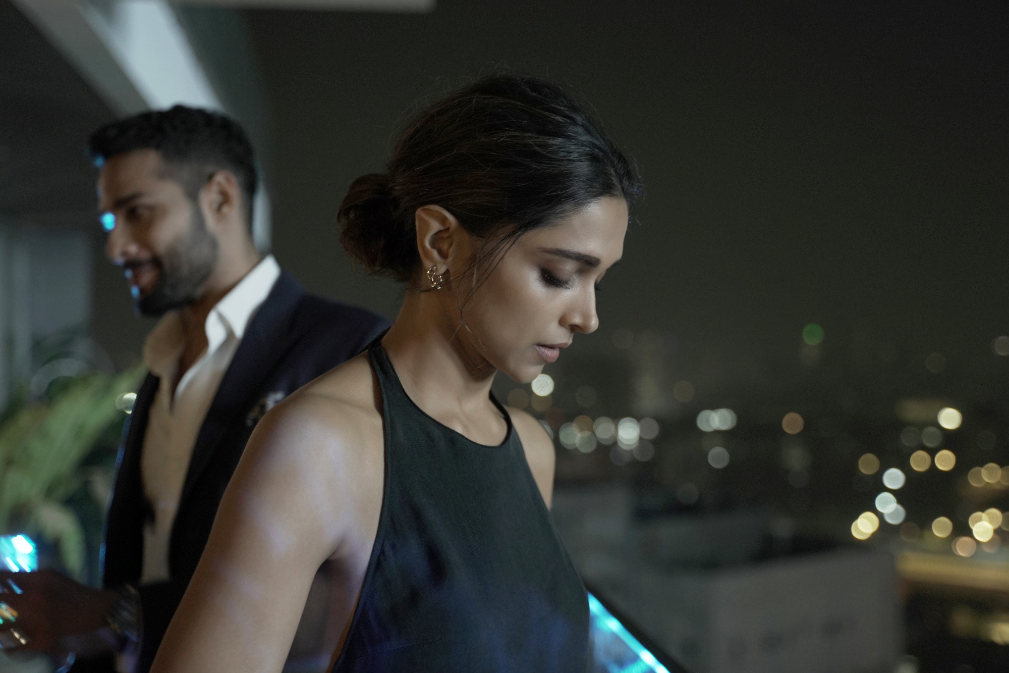 A still of Deepika Padukone and Siddhant Chaturvedi, standing on a balcony in a Mumbai apartment.