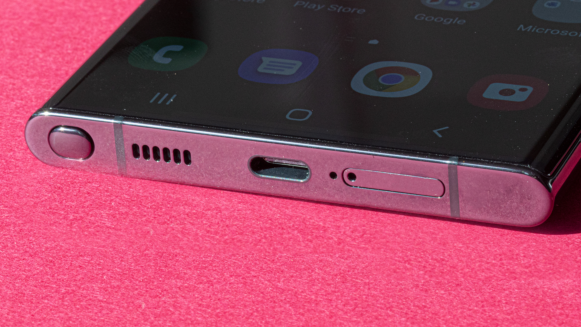 Close-up of the base of Samsung's Galaxy S22 Ultra on a pink background.