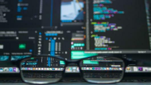 image of lines of code on multiple computer screens