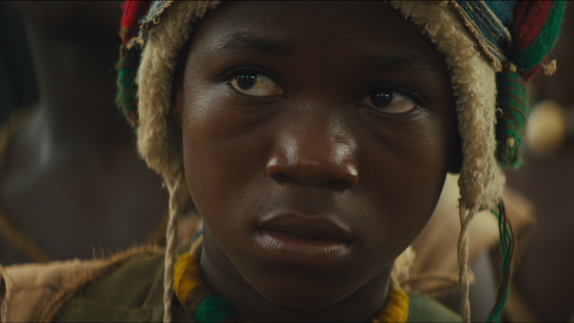 A young Black boy looks worried.