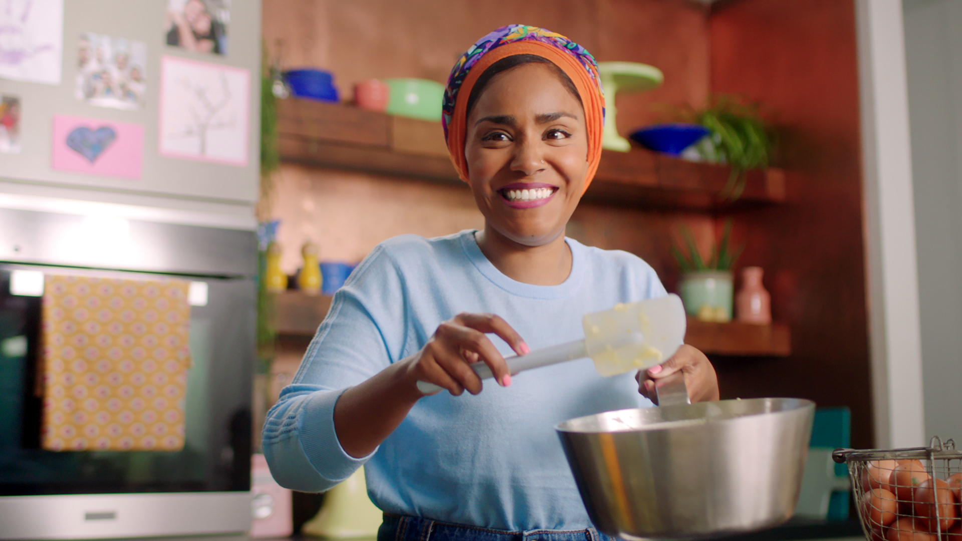 Nadiya Hussain holding a saucepan and spatula