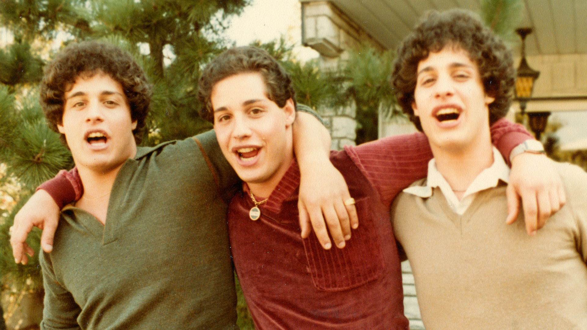 Grown triplet men group hug.
