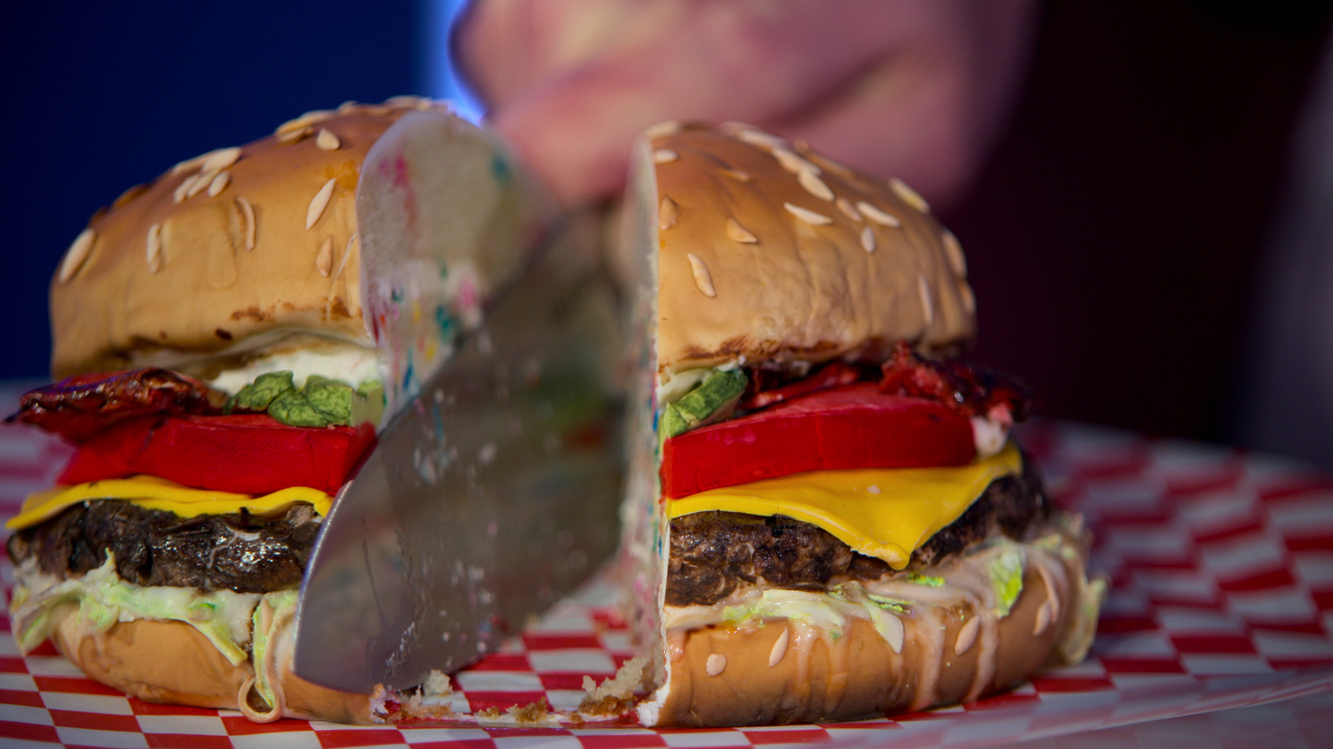 Close up of a knife cutting into a hamburger; it is cake.