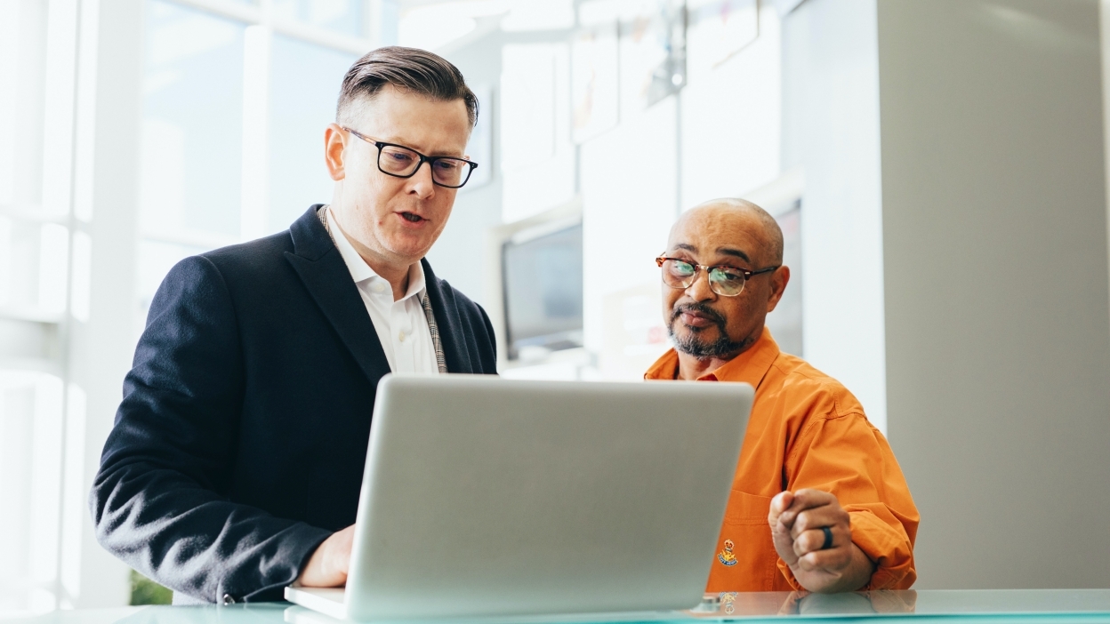 Two people staring at laptop