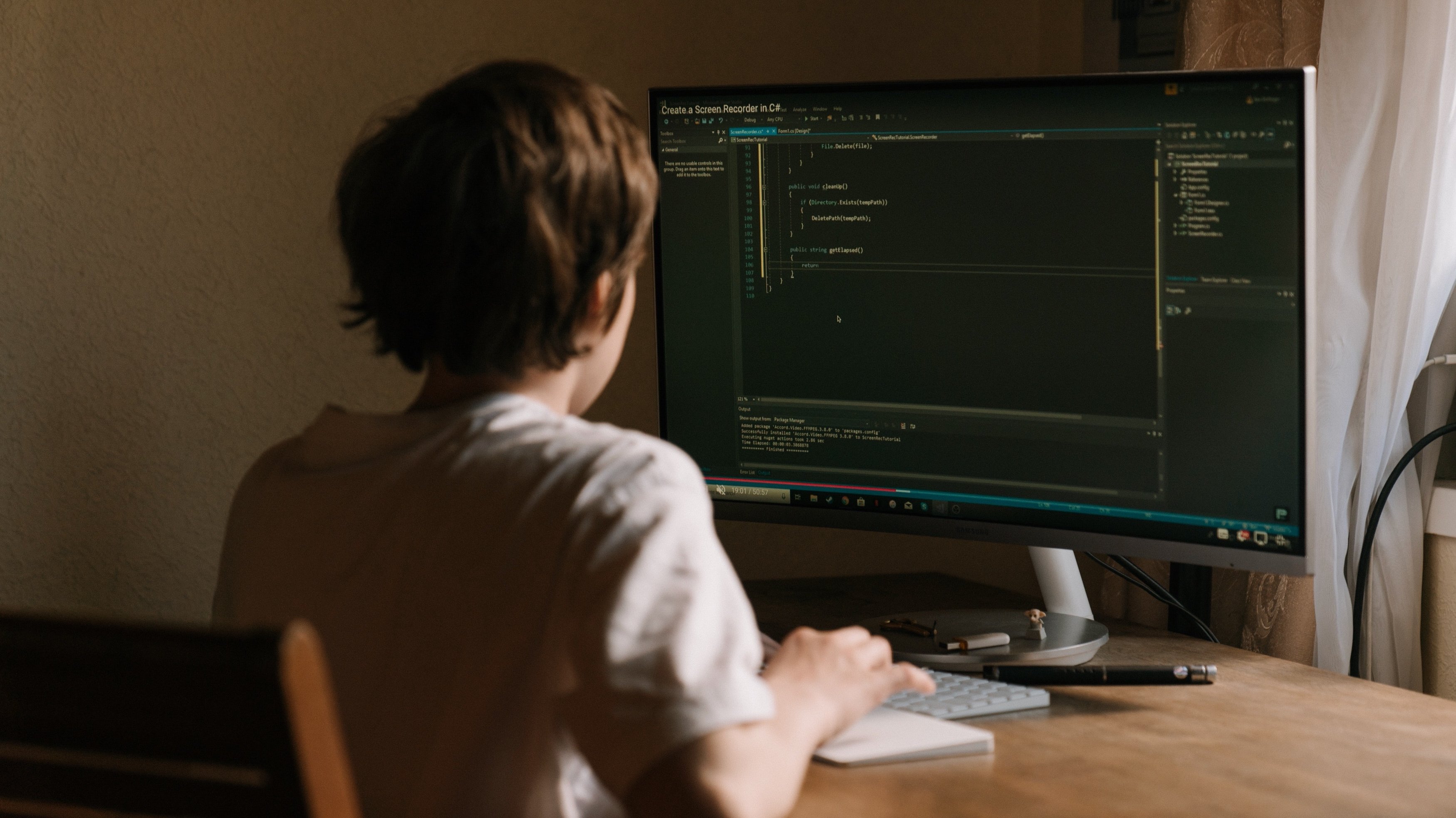 Child at computer showing coding screen