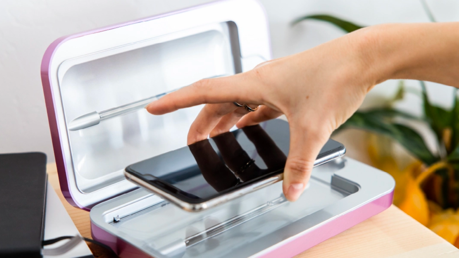 a person placing a phone into the phonesoap 3