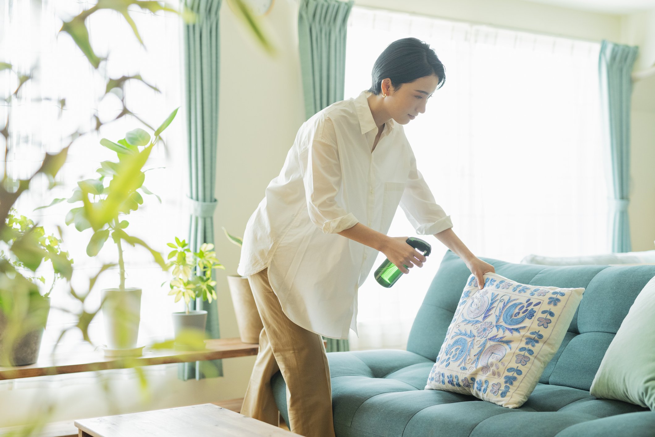 Woman cleaning with a spray bottle on a pillow